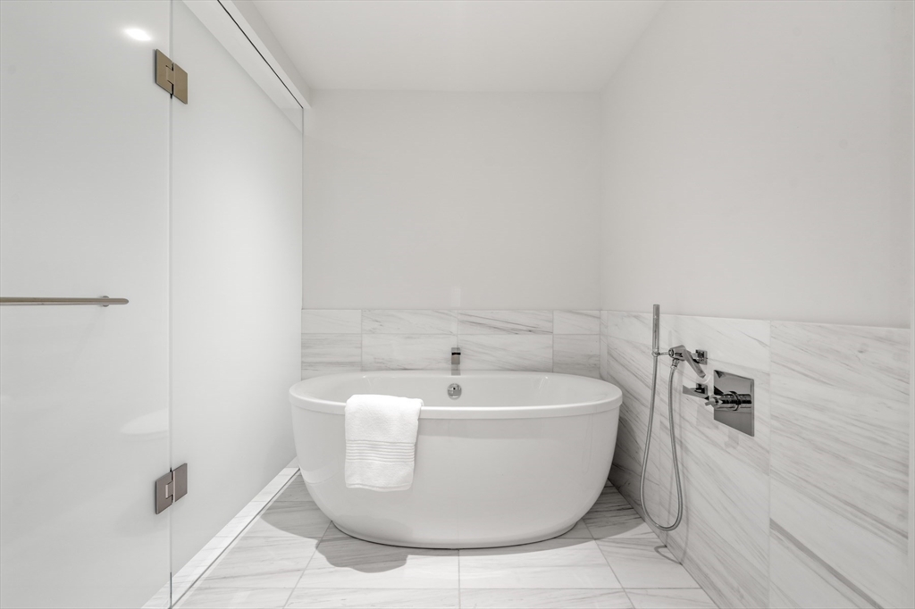 150 Seaport Boulevard, Unit 15CD Boston, MA 02210 - Photo 28 of 39 a white bath tub sitting in a bathroom