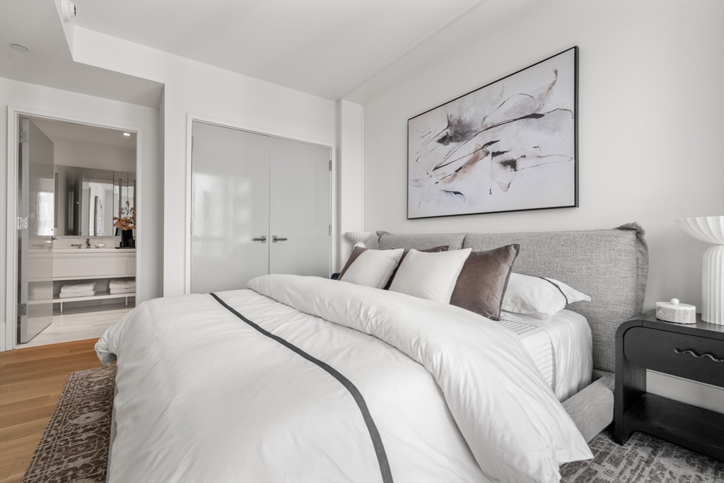 150 Seaport Boulevard, Unit 15CD Boston, MA 02210 - Photo 29 of 39 a bed room with a bed and a painting on the wall