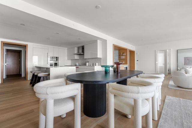 a living room with stainless steel appliances kitchen island granite countertop furniture and wooden floor