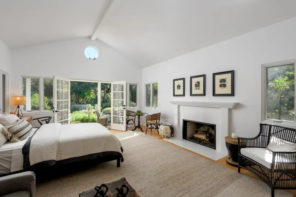 a bedroom with a bed a couch and large window