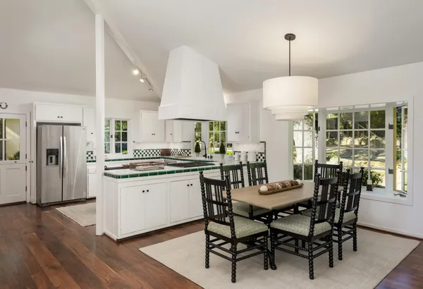 a kitchen with stainless steel appliances a dining table chairs and a chandelier
