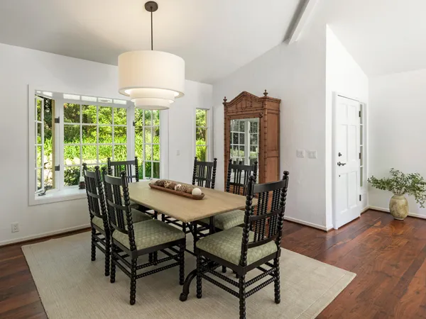 a dining room with furniture window and wooden floor