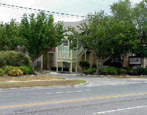 6702 Everhart Road, Unit S101 Corpus Christi, TX 78413 - Photo 1 of 4 a tall building with trees in front of it