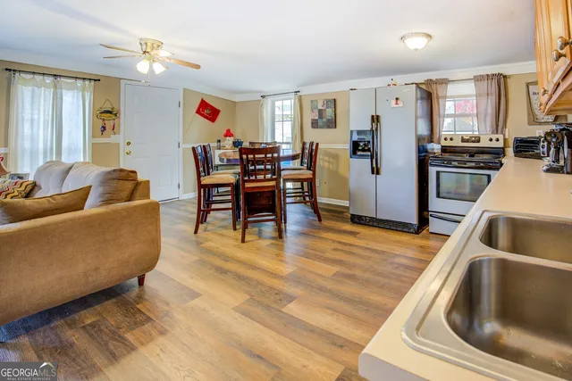 a living room with stainless steel appliances furniture or kitchen view and a refrigerator