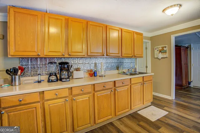 a kitchen with stainless steel appliances granite countertop a sink a refrigerator and cabinets