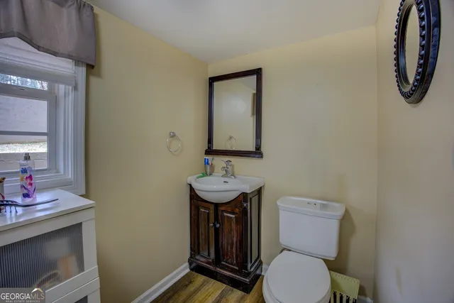 a bathroom with a toilet a sink and a mirror