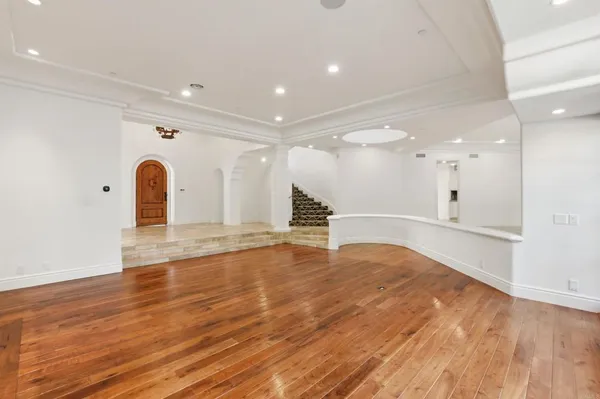 a living room with stainless steel appliances kitchen island granite countertop a stove and a large countertops with wooden floor