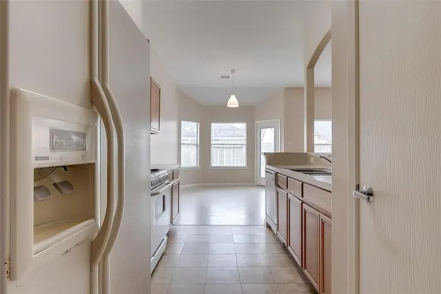 a kitchen with granite countertop a refrigerator and a sink