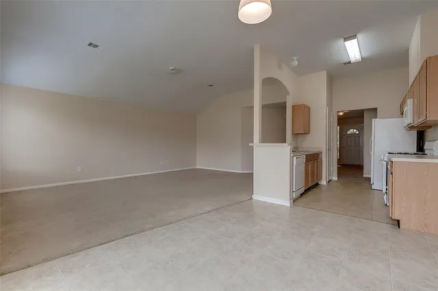 a view of a kitchen with furniture and a refrigerator