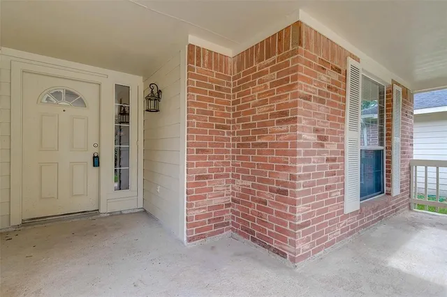 a view of wooden door and brick walls