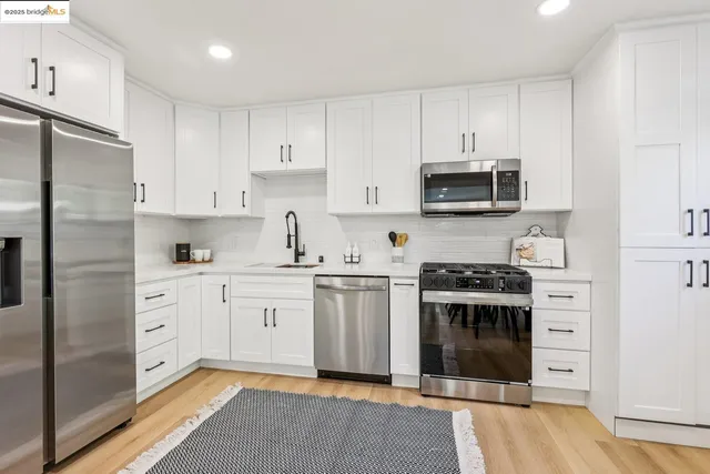 a kitchen with stainless steel appliances granite countertop a stove a sink and a refrigerator