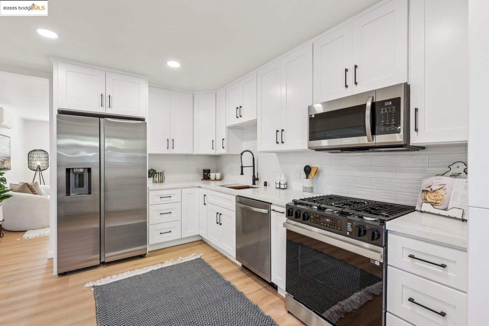 4185 Huckleberry Drive Concord, CA 94521 - Photo 14 of 33 a kitchen with stainless steel appliances white cabinets a stove a microwave a refrigerator a sink and cabinets
