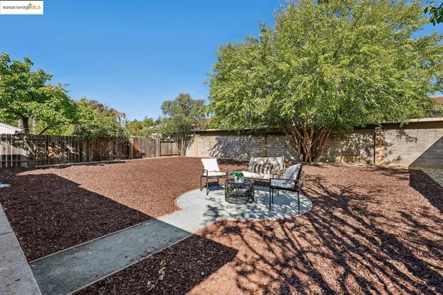 a view of a patio with table and chairs with wooden fence and floor