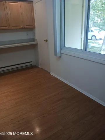 a view of a closet area with wooden floor