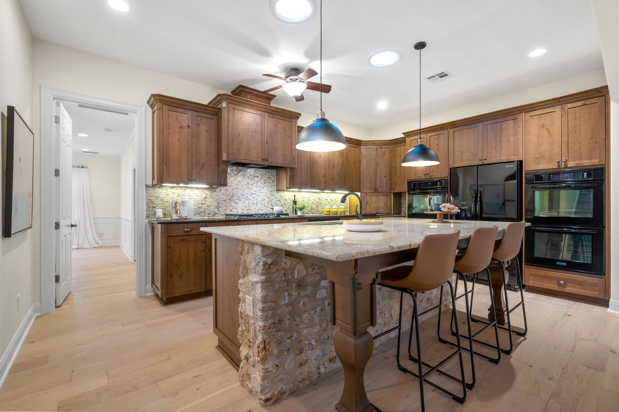 3701 Copper Ridge Court Austin, TX 78734 - Photo 10 of 30 a kitchen with stainless steel appliances kitchen island granite countertop a table chairs and a refrigerator