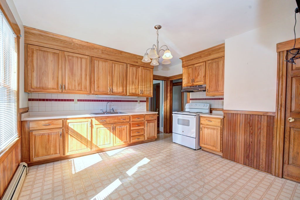 89-91 Larchwood Road Methuen, MA 01844 - Photo 16 of 39 a kitchen with stainless steel appliances granite countertop a refrigerator a stove a sink dishwasher and wooden cabinets with wooden floor