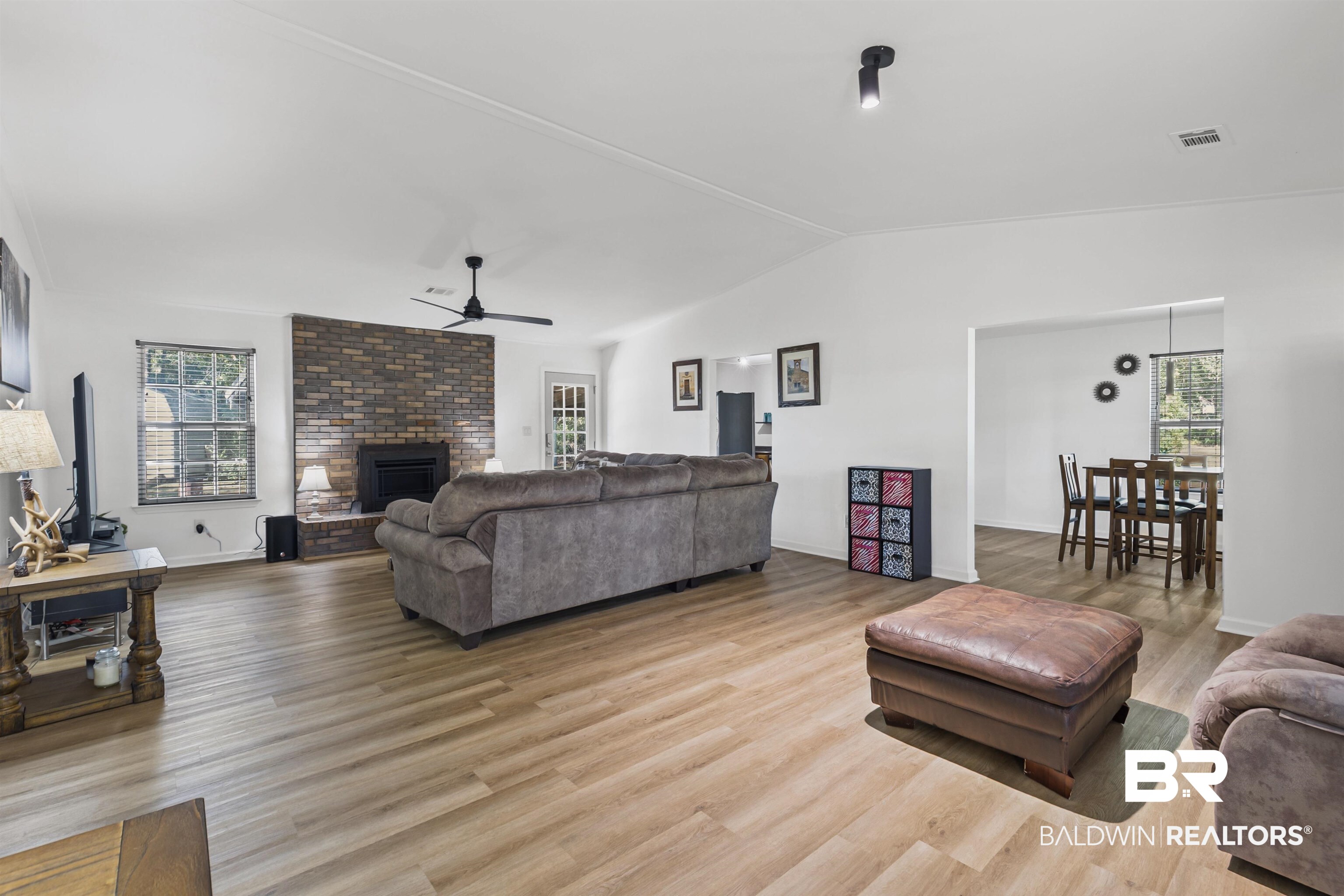 8911 Owassa Road Evergreen, AL 36401 - Photo 10 of 24 Living area featuring vaulted ceiling, light wood-style flooring, a fireplace, and a ceiling fan