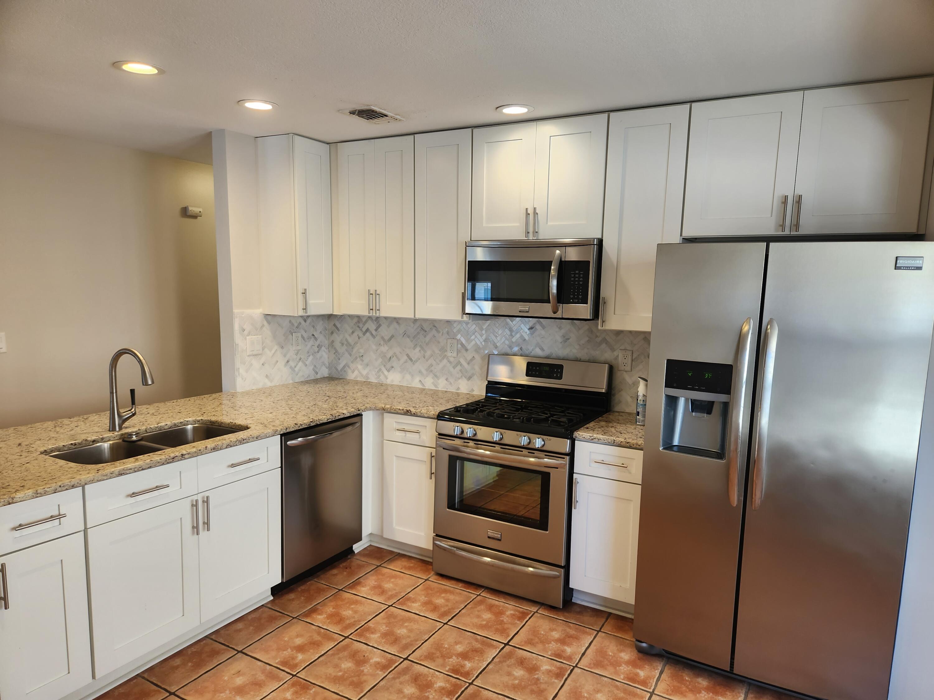 52 Rue D Honfleur Destin, FL 32541 - Photo 5 of 15 a kitchen with stainless steel appliances granite countertop a stove a sink and a refrigerator