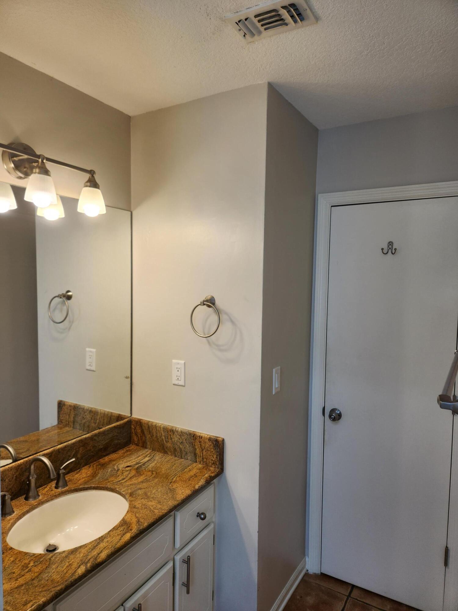 52 Rue D Honfleur Destin, FL 32541 - Photo 9 of 15 a bathroom with a granite countertop sink a mirror and a shower