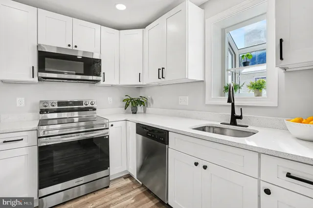 a kitchen with white cabinets and appliances