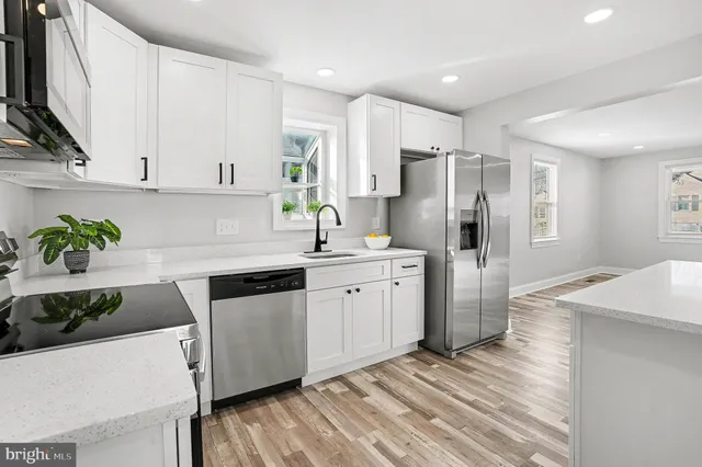 a kitchen with white cabinets and refrigerator