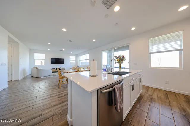 a large kitchen with stainless steel appliances a large counter top a stove and a refrigerator