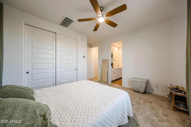 a bedroom with a bed and a ceiling fan