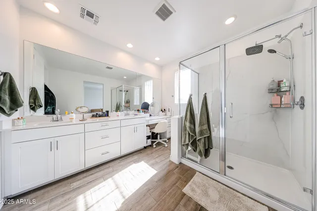 a bathroom with a double vanity sink mirror and shower
