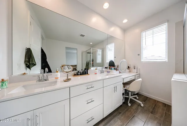 a bathroom with double vanity sink a mirror a vanity and a window