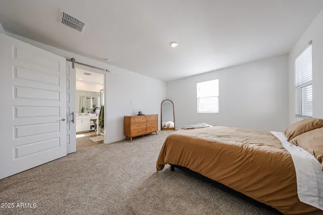 a spacious bedroom with a bed and a window