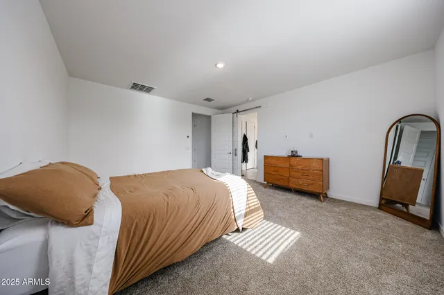 a bedroom with a bed and a chair