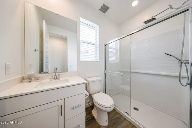 a bathroom with a sink a toilet and shower