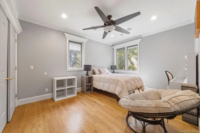 a spacious bedroom with a bed a chandelier and dresser