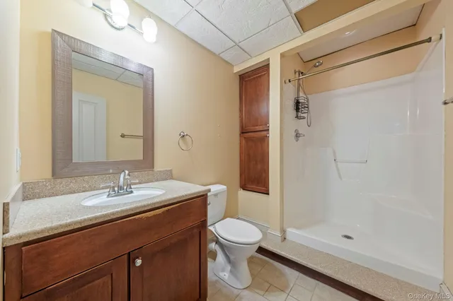 a bathroom with a sink a toilet and shower