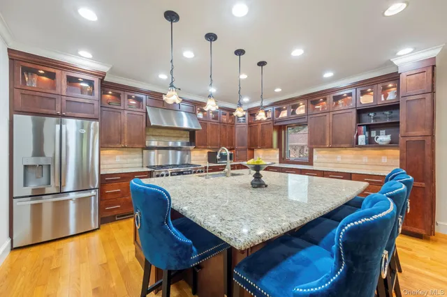 a kitchen with stainless steel appliances granite countertop a kitchen island a stove a table and chairs
