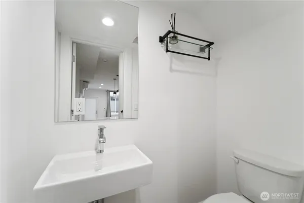 a bathroom with a toilet a sink and mirror