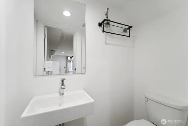 a bathroom with a toilet a sink and mirror