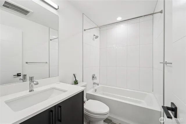 a bathroom with a sink a toilet and a large mirror