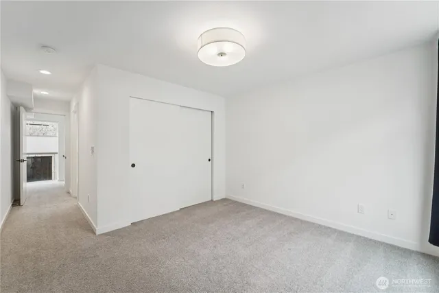 an empty room with closet and a chandelier fan