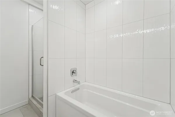 a white bath tub sitting next to a white sink and vanity
