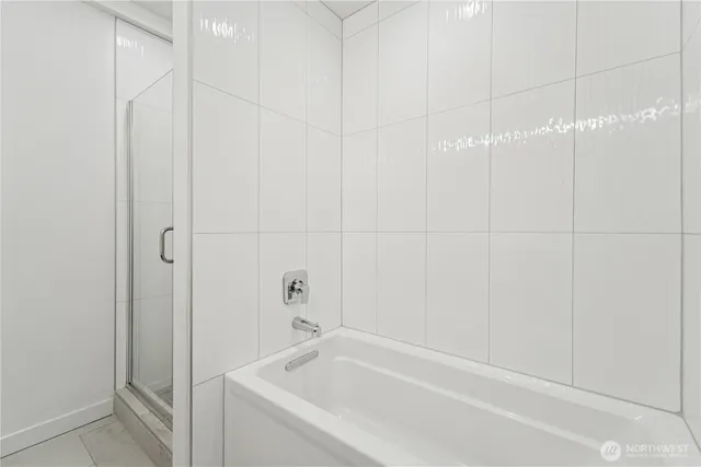 a white bath tub sitting next to a white sink and vanity