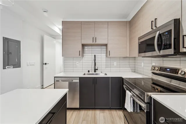a kitchen with a sink stove and microwave