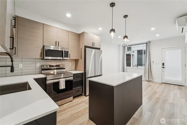 a kitchen with stainless steel appliances kitchen island a sink stove and refrigerator