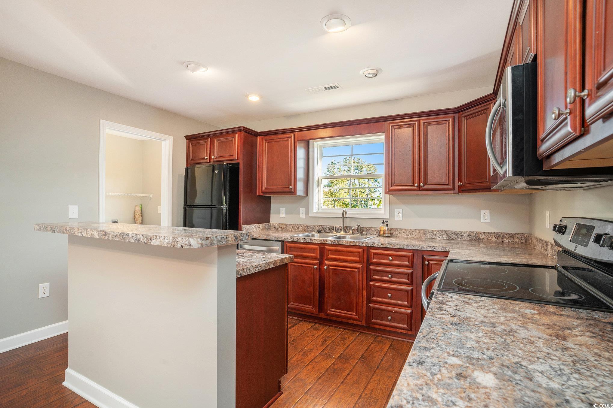 265 Georgia Mae Loop Conway, SC 29527 - Photo 17 of 28 Kitchen with appliances with stainless steel finishes, dark wood-type flooring, light countertops, a kitchen island, and recessed lighting