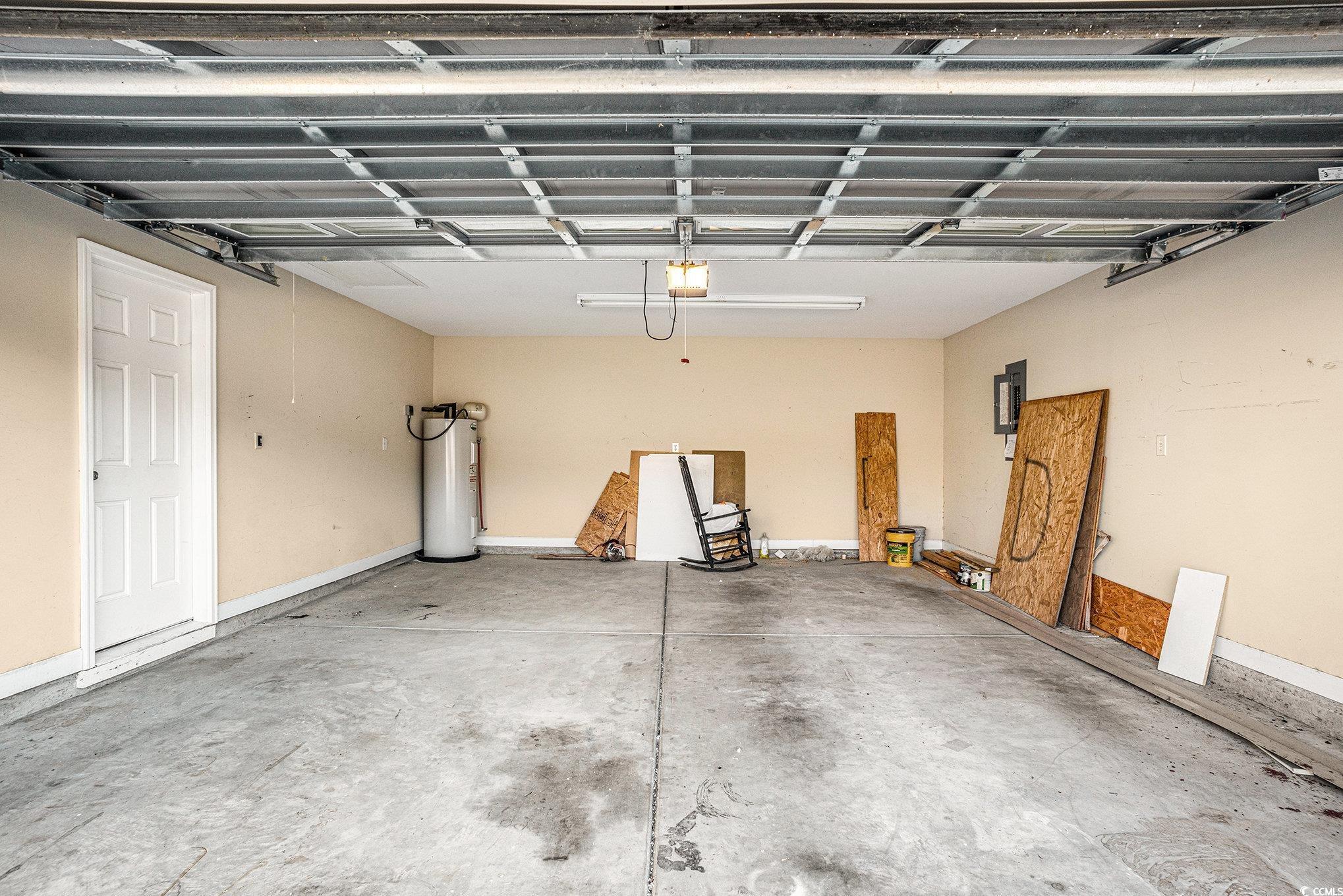 265 Georgia Mae Loop Conway, SC 29527 - Photo 18 of 28 Garage featuring electric water heater, electric panel, and a garage door opener