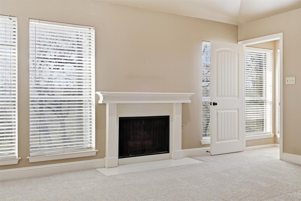 809 Cardinal Circle Bedford, TX 76022 - Photo 28 of 40 Fireplace in upstairs primary bedroom with lots of windows showing off the treehouse views!
