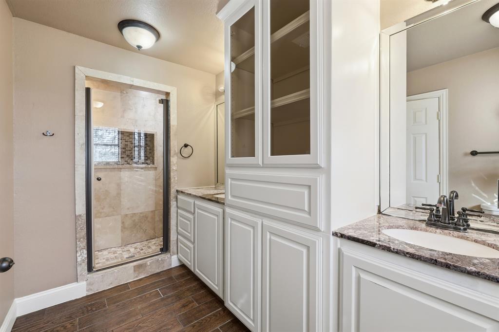 809 Cardinal Circle Bedford, TX 76022 - Photo 29 of 40 Beautifully updated primary bathroom with plenty of storage and a walk-in shower.
