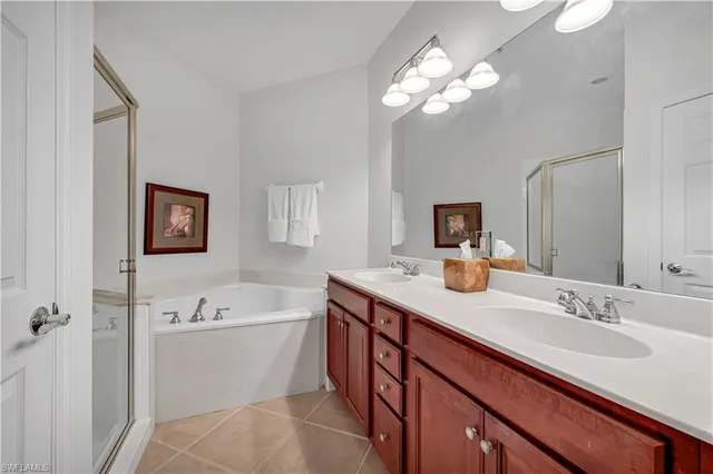 a bathroom with a sink double vanity granite tub and a mirror