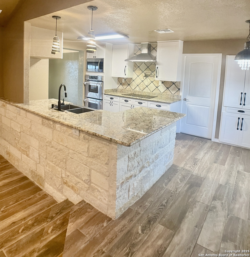3010 Triple Tree Drive China Grove, TX 78263 - Photo 7 of 18 a view of a kitchen with kitchen island a sink wooden floor and counter top space