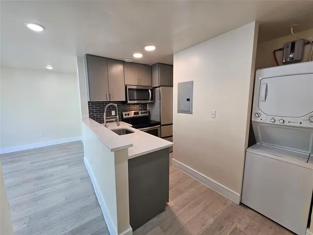 a kitchen with kitchen island a sink a stove a refrigerator and cabinets